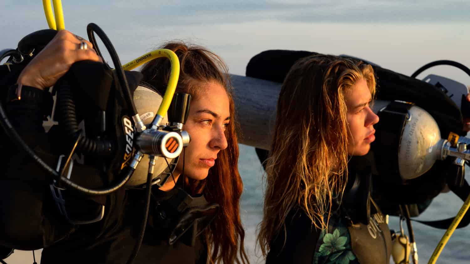 Professional Female Scuba Diver holding tanks on their shoulders