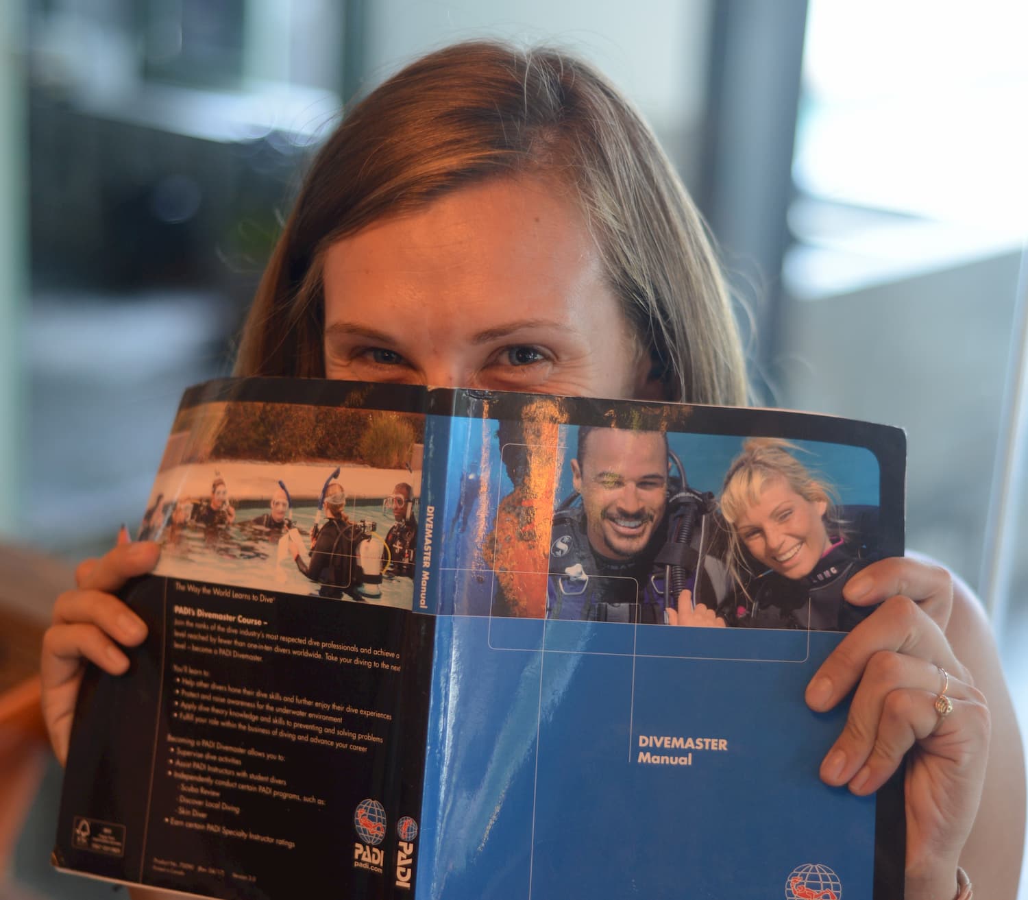 Divemaster Trainee reading in the Divemaster Manual to complete written assignments